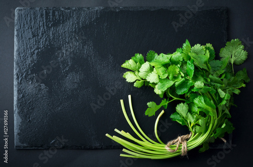 Fresh green coriander, coriander leaves on a black background. Selective focus.