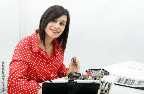 brunette woman technician repairs a computer
