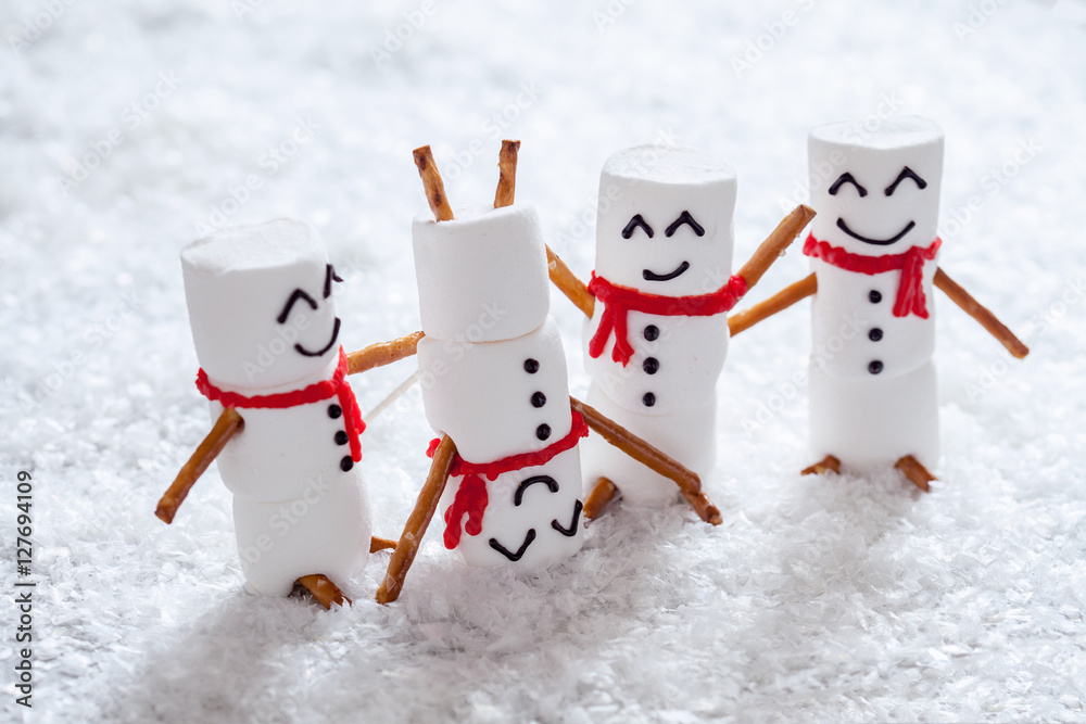 Fototapeta Szczęśliwe śmieszne bałwanki z pianki marshmallow na śniegu