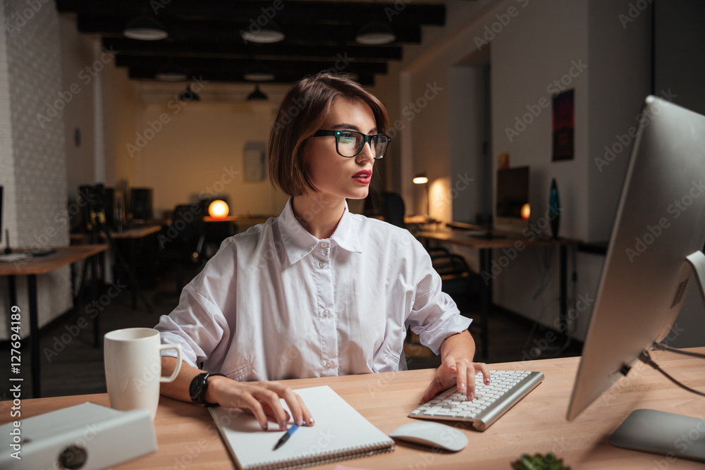 Concentrated attractive young businesswoman working with computer in office Concentrated attractive young businesswoman working with computer in office