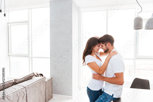 Sensual young couple standing and hugging