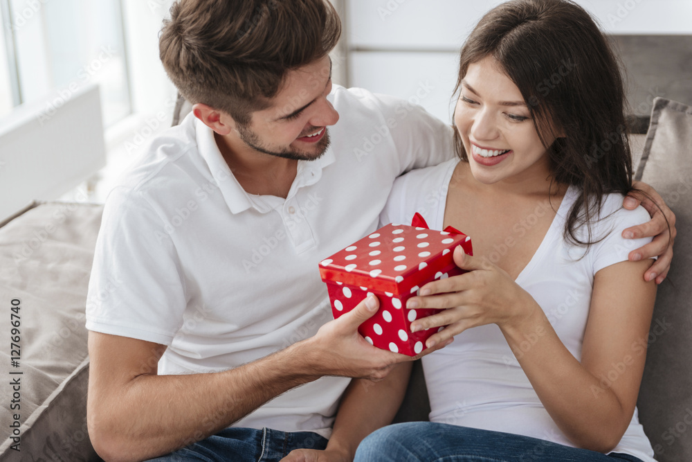 Happy man giving present to his girlfriend at home Happy man giving present to his girlfriend at home