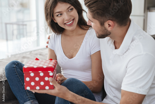 Woman taking present from her boyfriend at home