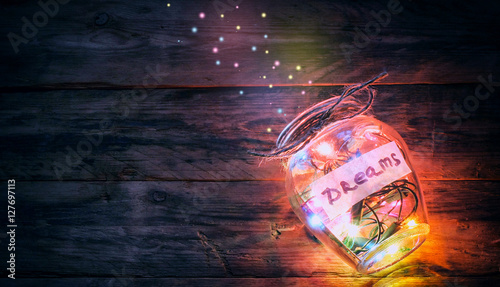 garlands of colored lights in glass jar with dreams photo