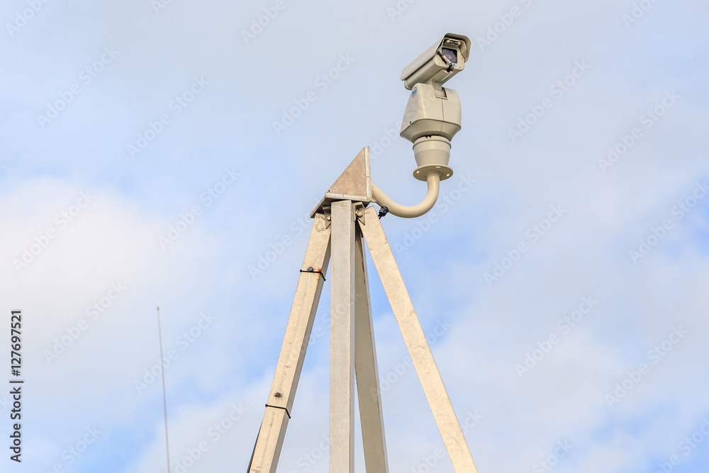 Security camera, CCTV with blurred sky background Security camera, CCTV with blurred sky background