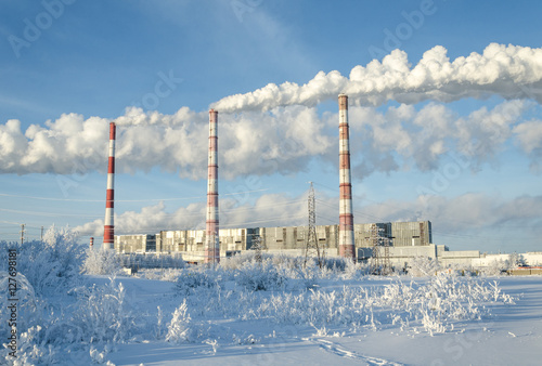 Gas power station in cold winter landscape. Pipes with smoke. Energy industry concept. 