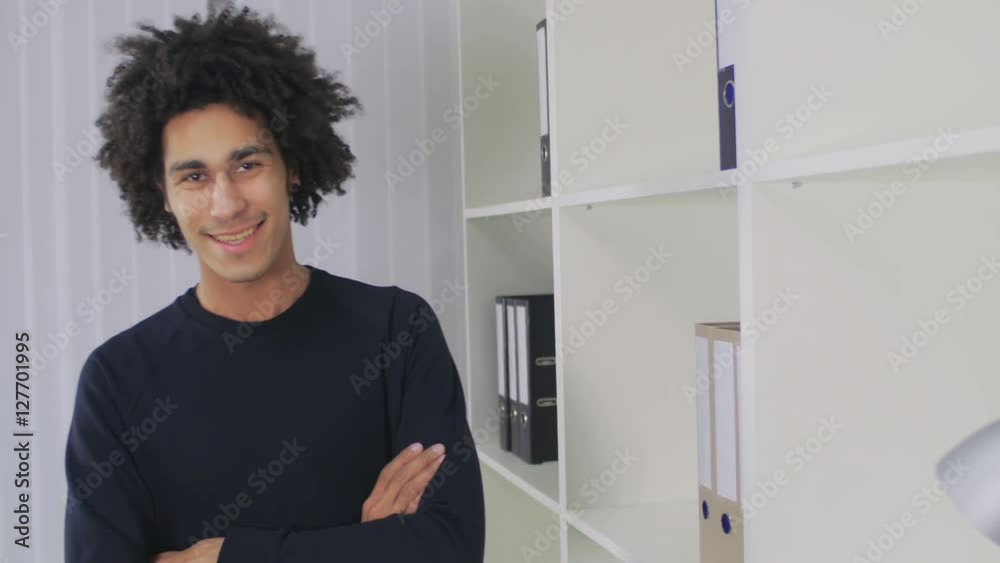 The young Afro-American put the folder with documents in a cupboard The young Afro-American put the folder with documents in a cupboard