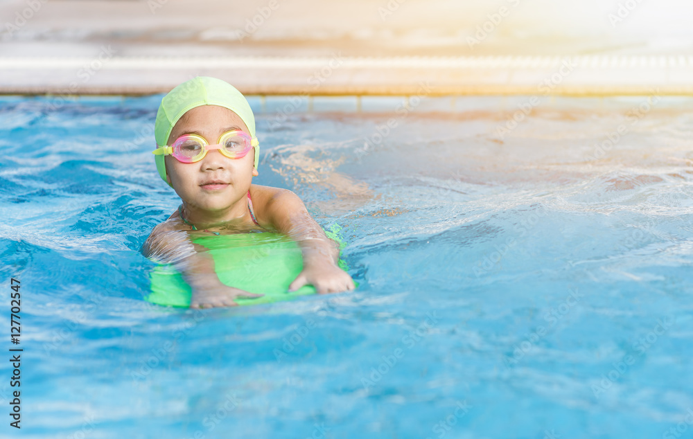 cute little girl learning how to swim