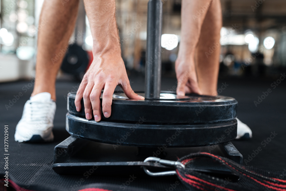 Obraz premium Bodybuilder puts the barbells