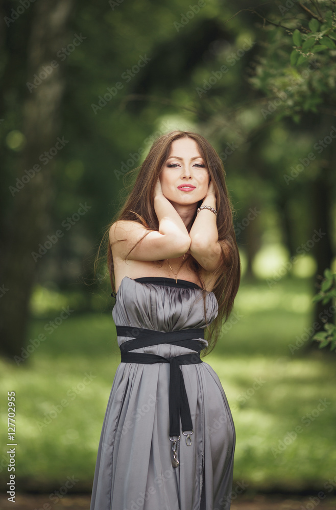 Beauty Romantic Girl Outdoors. Teenage Model with Casual Dress in park. Blowing Long Hair. Beauty Romantic Girl Outdoors. Teenage Model with Casual Dress in park. Blowing Long Hair.
