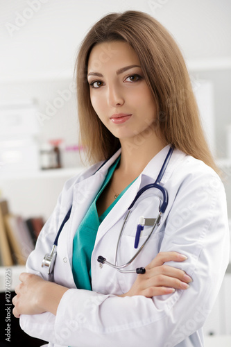 Female medicine doctor standing with her arms crossed photo