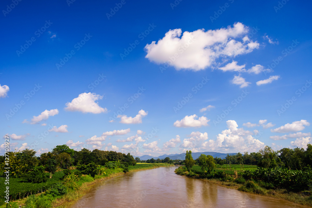 background of blue sky and white clouds with brown river.