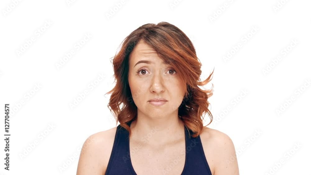 Upset young beautiful girl over white background. Slow motion. Upset young beautiful girl over white background. Slow motion.