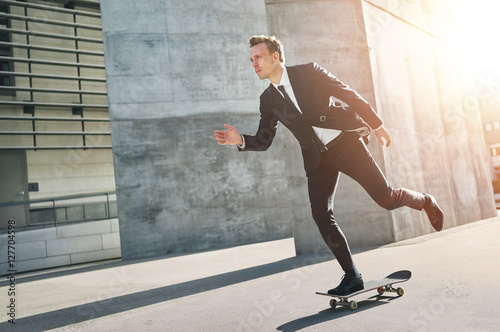 Extremal man wearing suits rides a skateboard