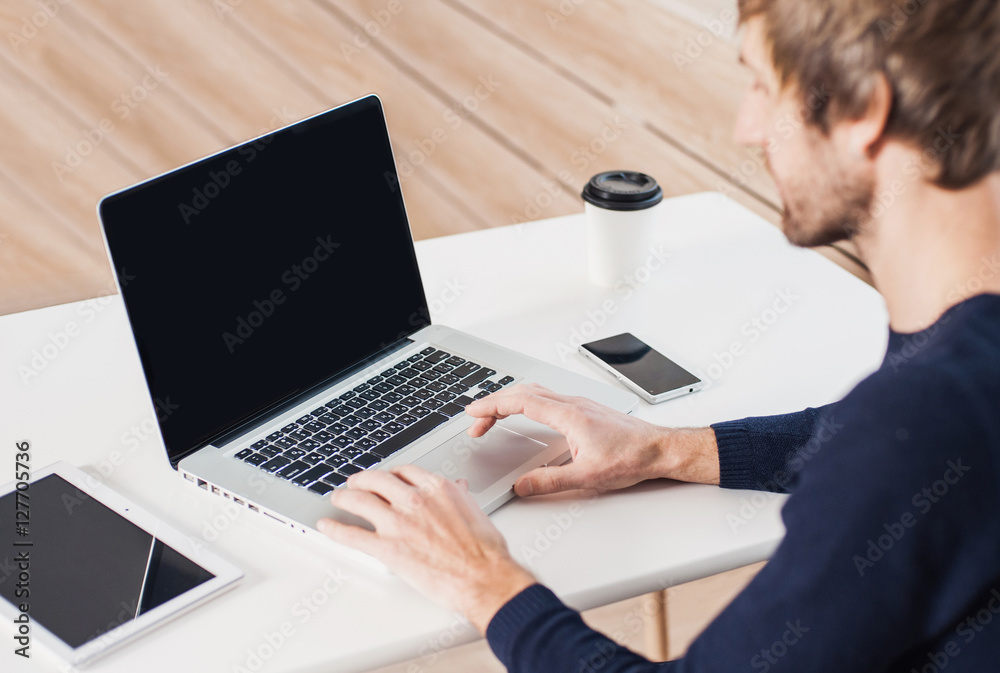 Business man using laptop computer. Male hand typing on laptop keyboard. Blank computer monitor Business man using laptop computer. Male hand typing on laptop keyboard. Blank computer monitor