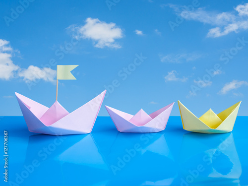 Leadership concept, Craft of paper boat (Origami bird) on blue b