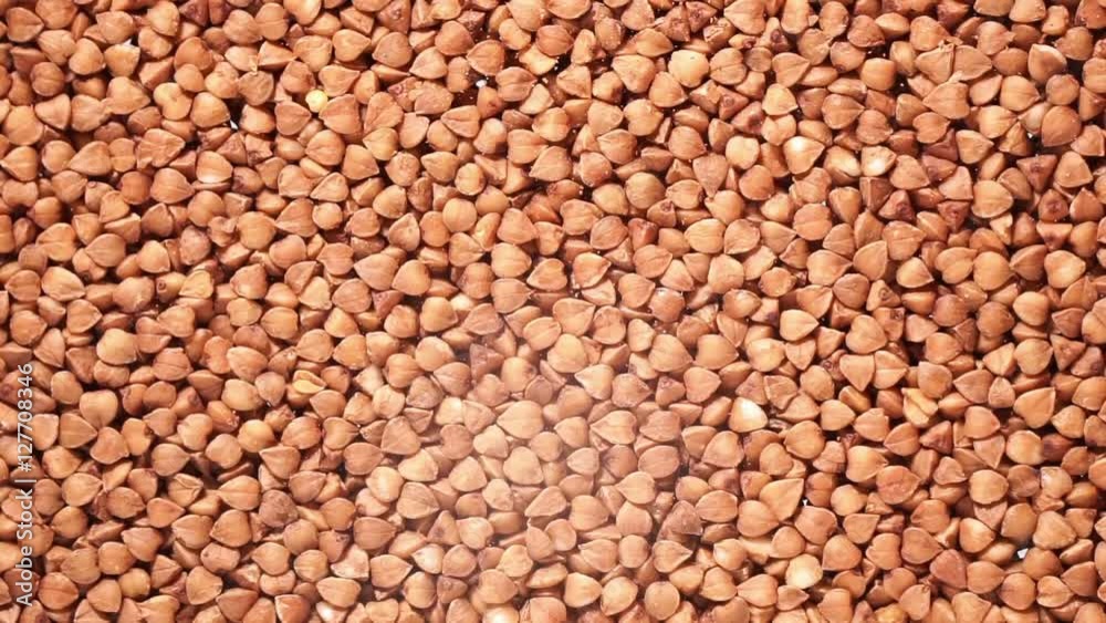 Falling buckwheat on a white background fills the screen.