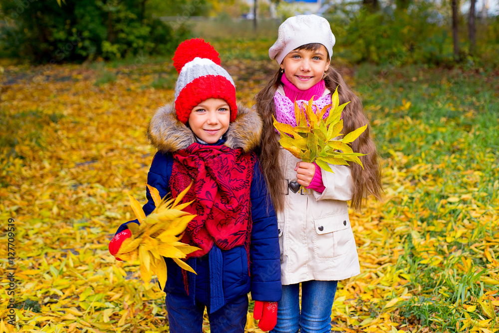 two little girls in autumn park with leafs two little girls in autumn park with leafs