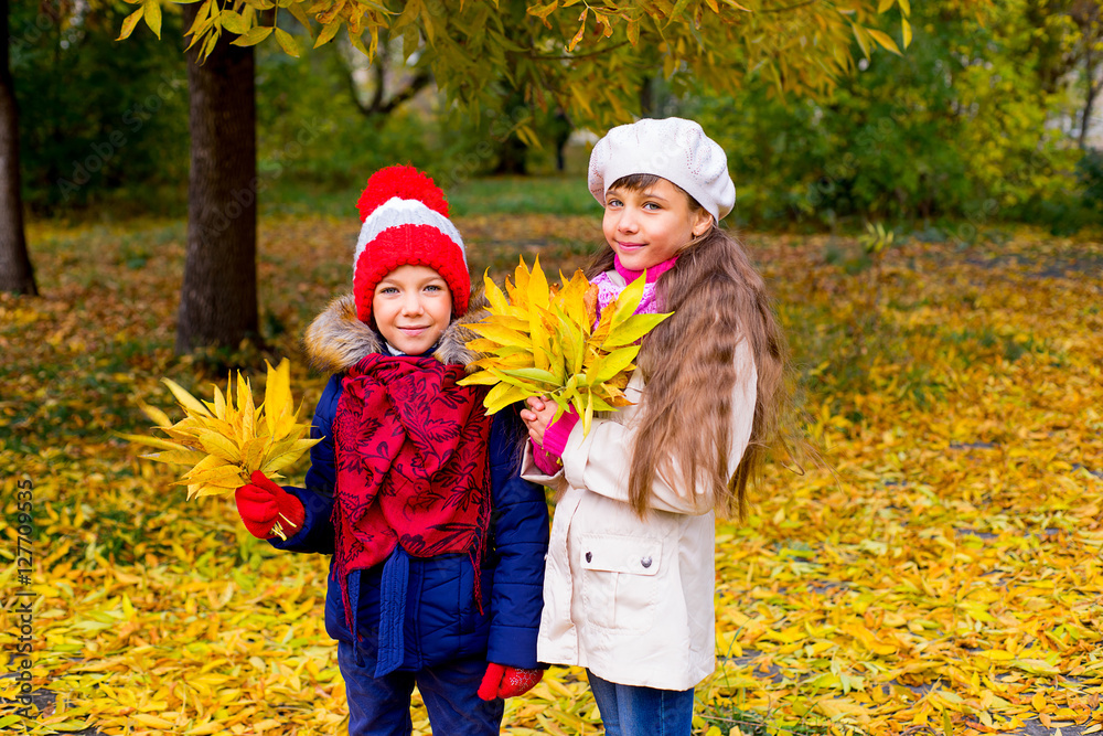 two little girls in autumn park with leafs two little girls in autumn park with leafs