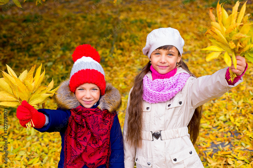 two little girls in autumn park with leafs two little girls in autumn park with leafs