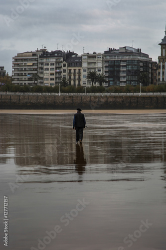 Persona mayor paseando por la orilla de una playa © miunicaneurona