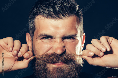 Fotografie Funny bearded man twirls moustache