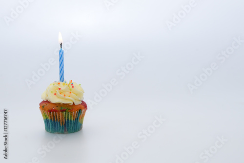 Cupcake with candle on white background