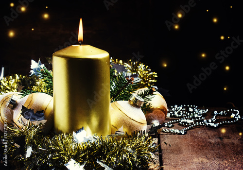 Golden burning candle, tinsel, Christmas balls, beads and spruce