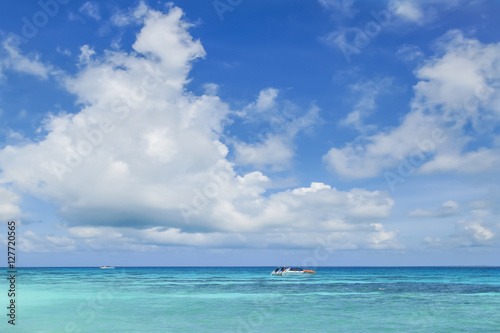Tourist boat in the sea with cloudy blue sky