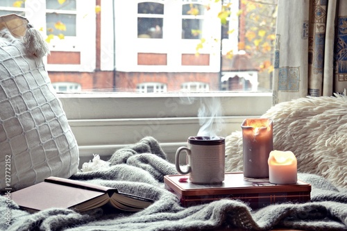 Cozy home. Candles, book and cup of tea photo