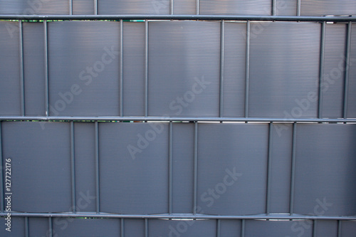 Modern steel fencing texture with black or anthracite woven plastic panels for privacy