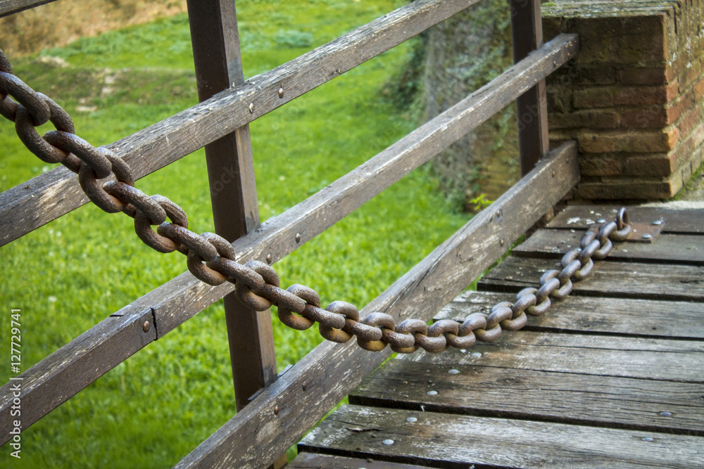 Naklejka premium large iron chain on an old castle bridge