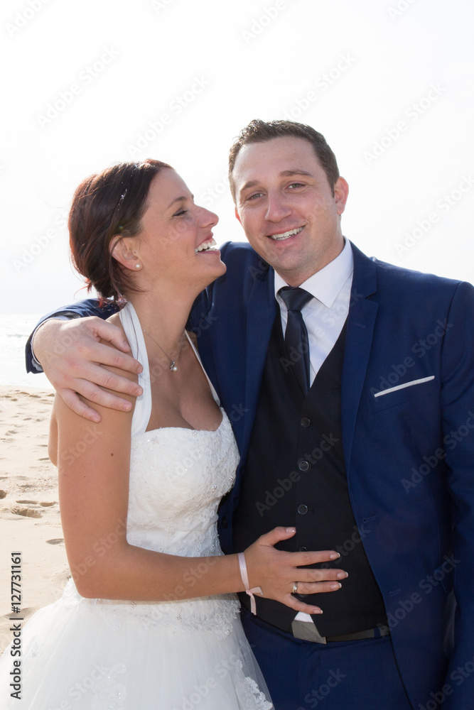 Lovely married couple smiling and hugging on the beach Lovely married couple smiling and hugging on the beach