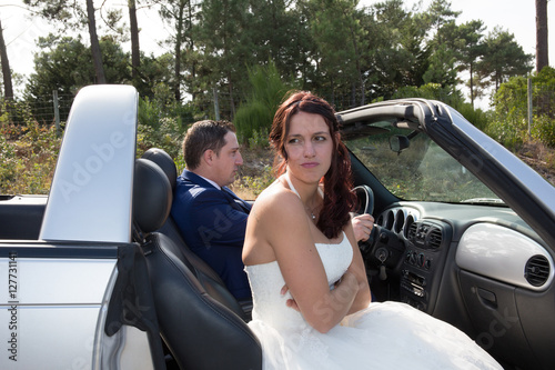 The groom and the bride in a convertible car © OceanProd