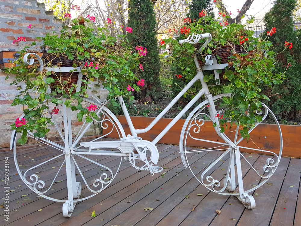 Old white bicycle decorated with flowers