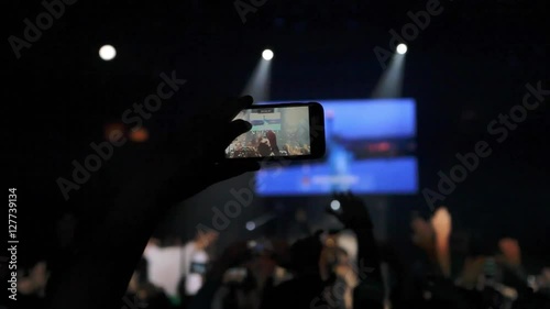 Fans waving their hands and hold the phone with digital displays
