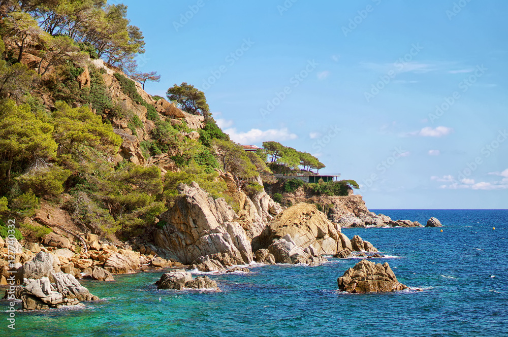 Beautiful natural rock near of Tossa de Mar, Costa Brava, Spain. Bay and crystal clear water of Mediterranean Sea. Amazing blue green sea and sunny day.