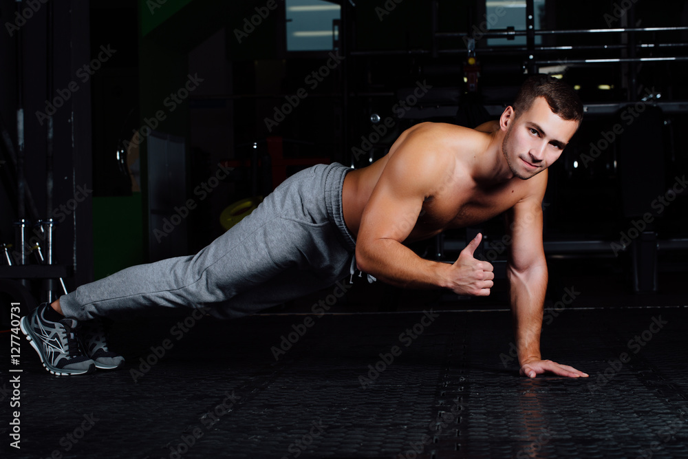 Naklejka premium man doing push-up at gym .