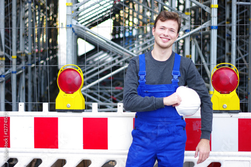 junger Mann in Arbeitskleidung auf der Baustelle photo