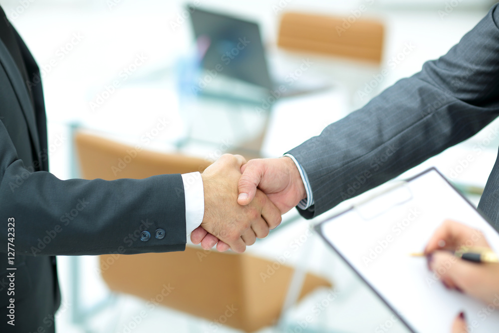 Successful handshake of business men in a working environment Successful handshake of business men in a working environment