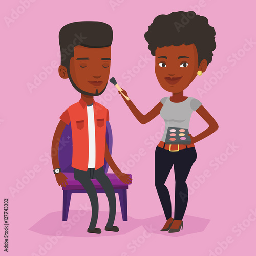 Visagiste doing makeup to young man.