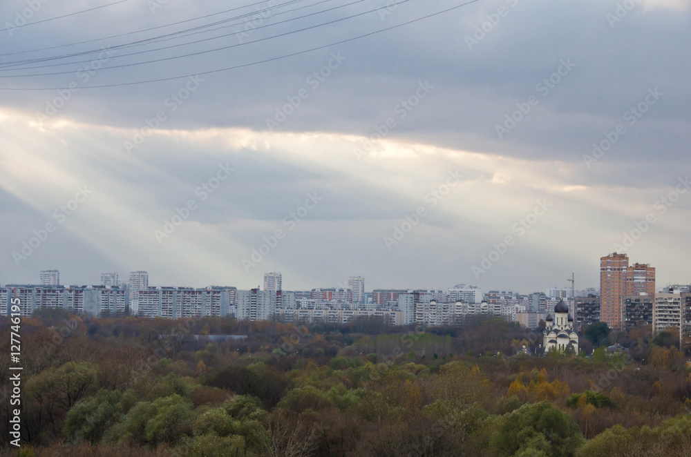 Obraz premium Sun rays in clouds above the town