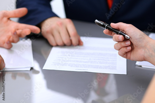 Business lady offering businessman black pen for signing a contract