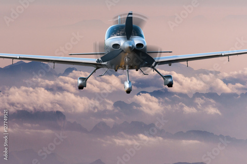 Privat Airplane flying above silhouette of high mountains at sunset. Travel concept and vacation background