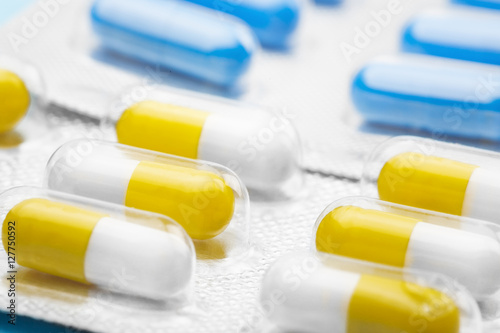 yellow and blue pills in plastic packaging