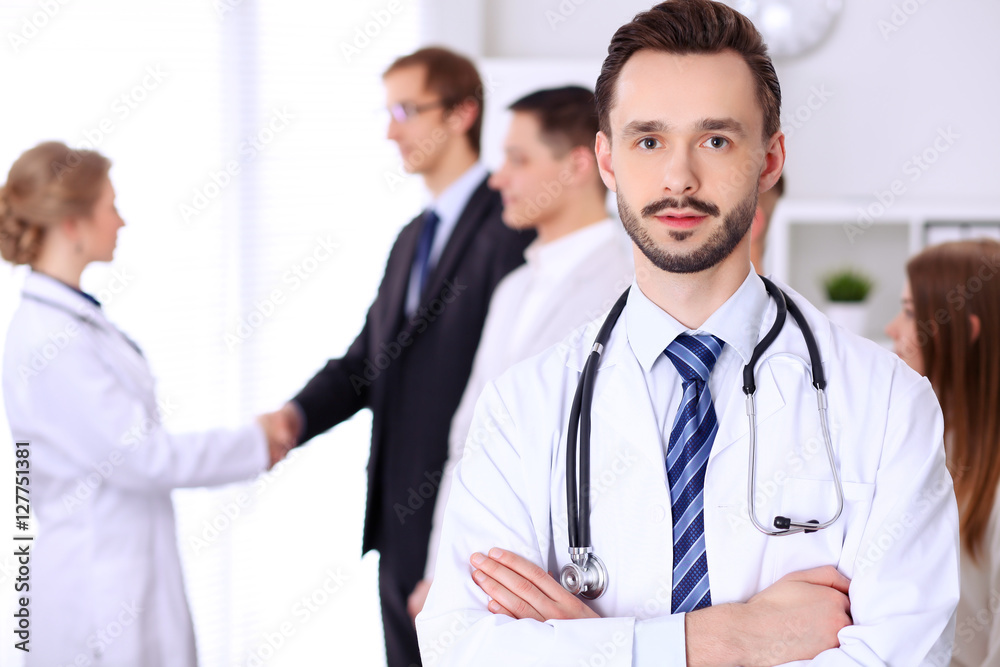 Friendly bearded male doctor with patients Friendly bearded male doctor with patients