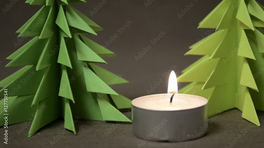 Burning candle with two origami tree Burning candle with two origami tree