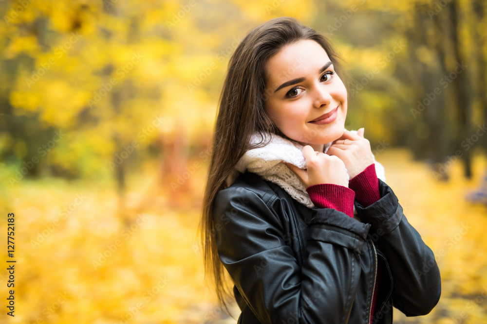 Beautiful elegant woman standing in a park in autumn Beautiful elegant woman standing in a park in autumn