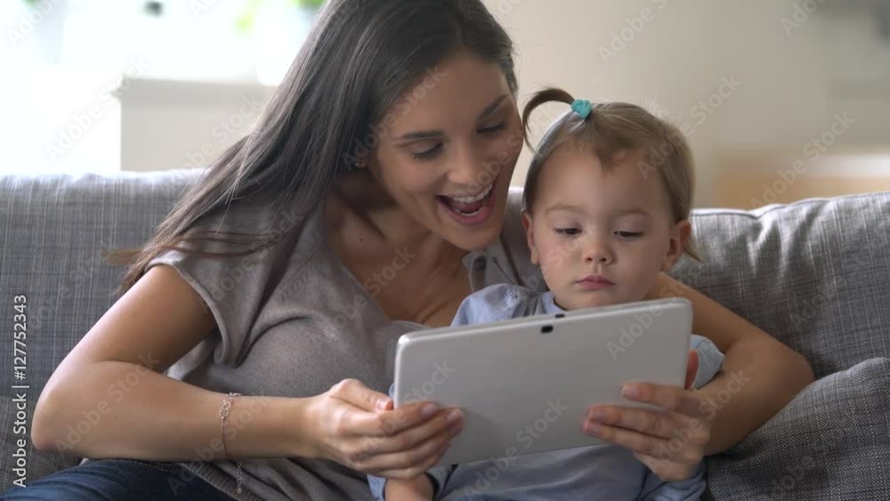 Mother and daugther using digital tablet at home Mother and daugther using digital tablet at home