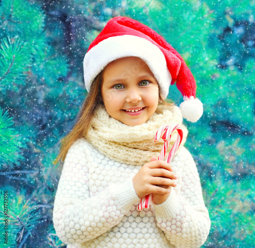 Christmas smiling child little girl in santa red hat with sweet